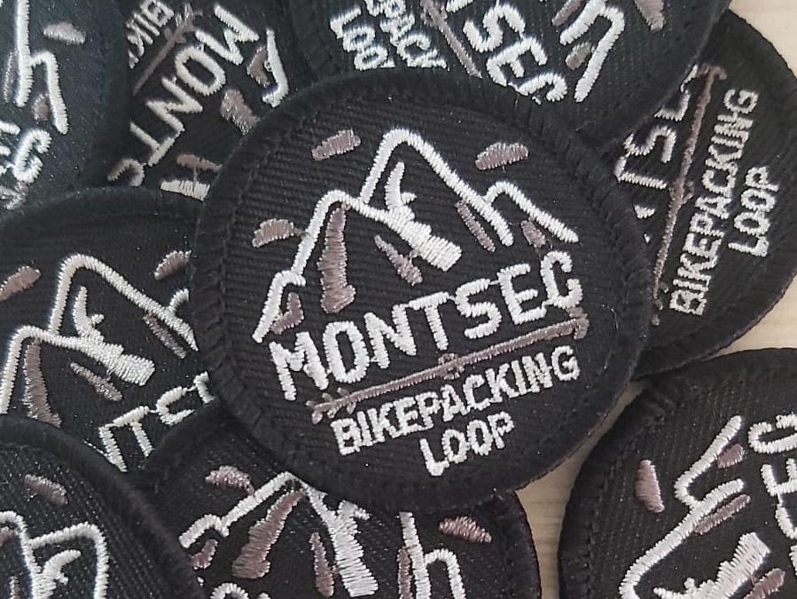 Producte: Pegats i Adhesius | Presentació: pack d'1 pegat i 2 adhesius | Territori Montsec: Montsec de l'Estall, Montsec d'Ares, Montsec de Rúbies. | Productor/a: Javi Castillo (Montsec BikePacking Loop).